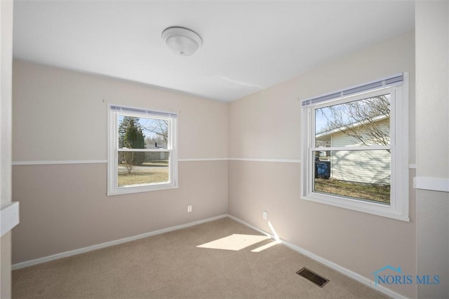 carpeted empty room with baseboards and visible vents