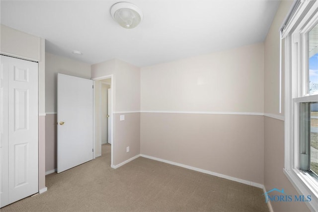 unfurnished bedroom with baseboards and carpet flooring