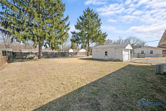 view of yard with an outdoor structure, central air condition unit, and a fenced backyard