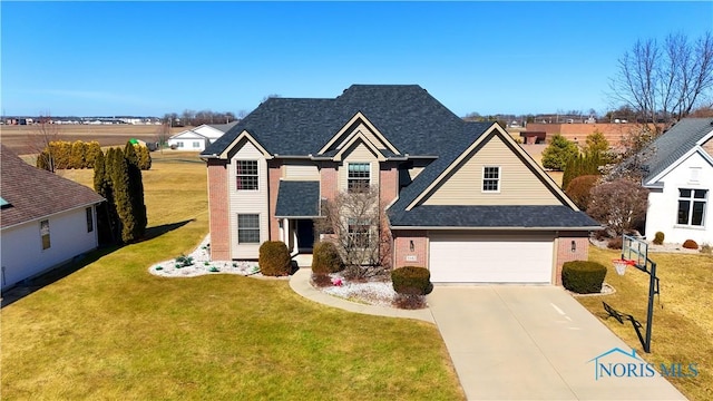 traditional home with driveway, roof with shingles, an attached garage, a front yard, and brick siding