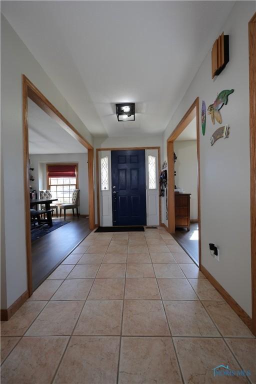 foyer with light tile patterned floors and baseboards