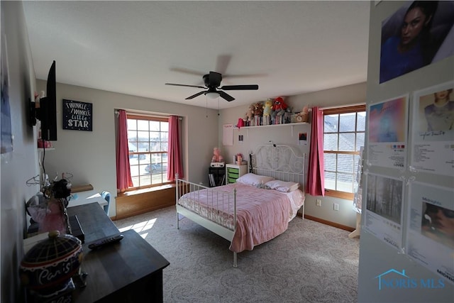 bedroom featuring multiple windows, carpet floors, baseboards, and ceiling fan