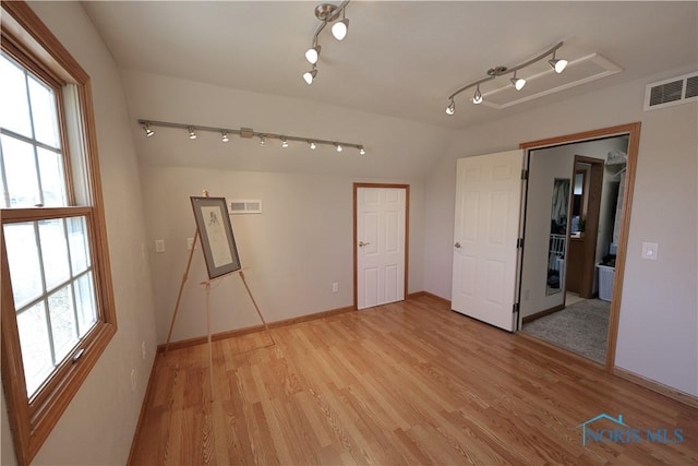 unfurnished bedroom featuring multiple windows, visible vents, and light wood-type flooring