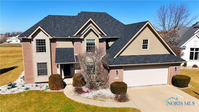 traditional-style home featuring a front lawn, an attached garage, brick siding, and driveway