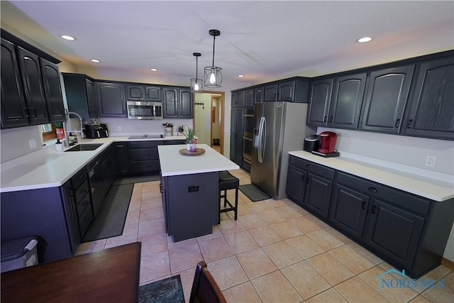 kitchen featuring a kitchen bar, a sink, a center island, stainless steel appliances, and light tile patterned floors