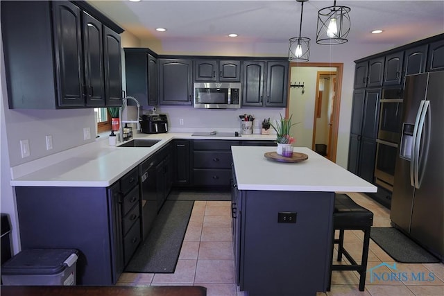 kitchen with a kitchen island, a kitchen bar, light tile patterned floors, appliances with stainless steel finishes, and a sink