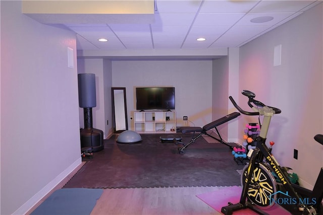 exercise room featuring a drop ceiling, recessed lighting, and baseboards