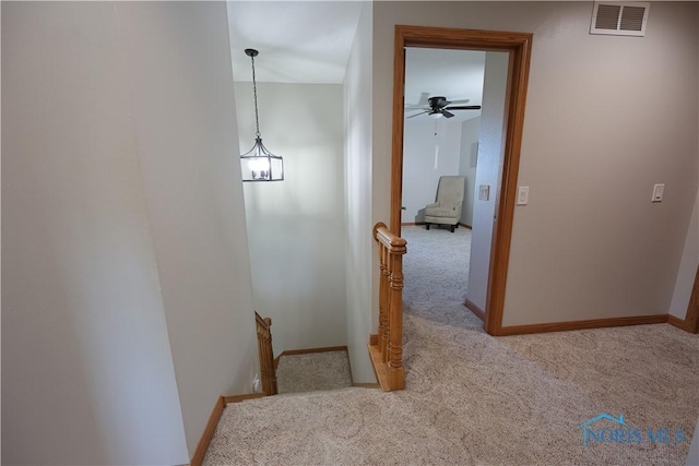 corridor featuring visible vents, baseboards, and carpet