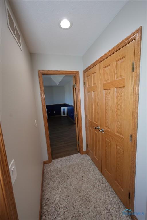 corridor featuring carpet flooring, baseboards, and visible vents