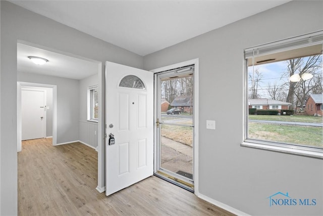 foyer entrance with baseboards and light wood finished floors