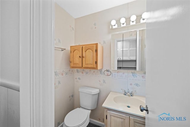 bathroom featuring toilet, tile walls, and vanity