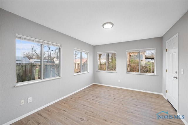 unfurnished room featuring baseboards and wood finished floors