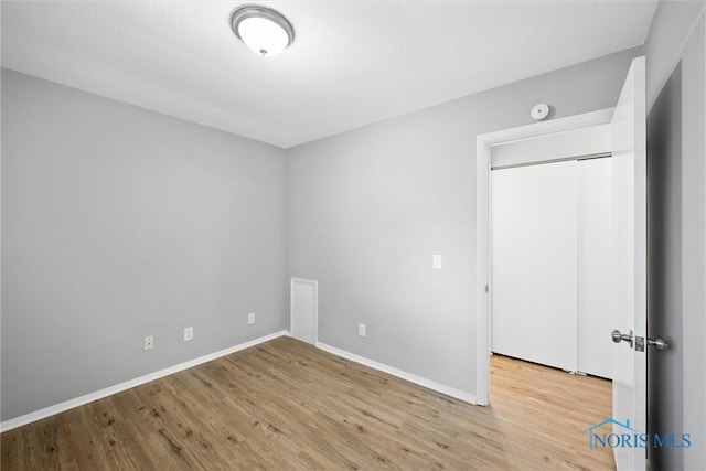 unfurnished bedroom with wood finished floors and baseboards