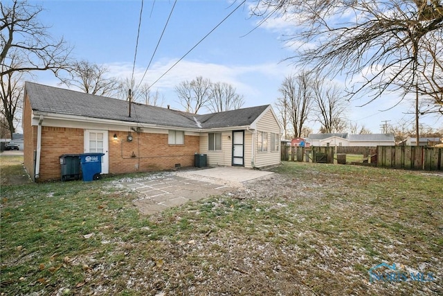 back of house with a patio, fence, a yard, crawl space, and brick siding