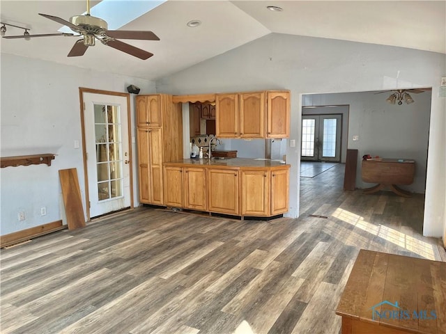 kitchen featuring ceiling fan, lofted ceiling, french doors, wood finished floors, and a sink