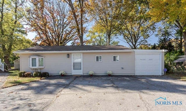 rear view of property with a garage and driveway