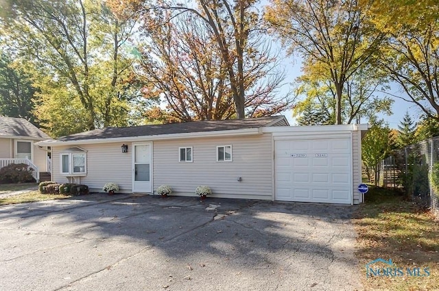 ranch-style house with fence and driveway