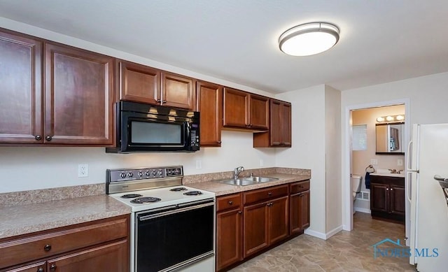 kitchen featuring white appliances, light countertops, baseboards, and a sink