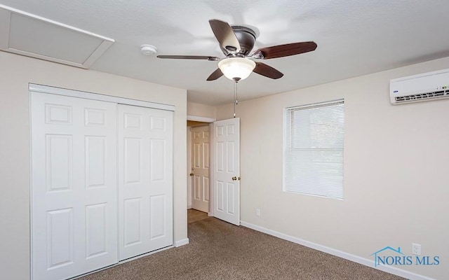 unfurnished bedroom with a ceiling fan, carpet, baseboards, an AC wall unit, and a closet