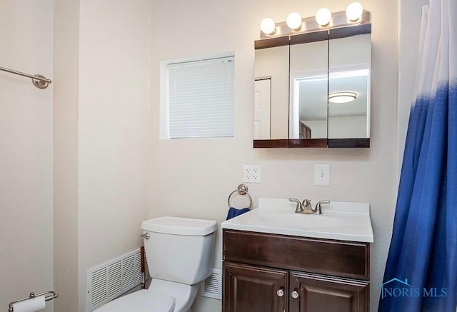 bathroom featuring vanity, toilet, and visible vents