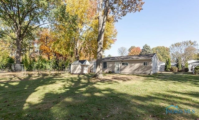 view of yard with a fenced backyard, a storage shed, and an outdoor structure