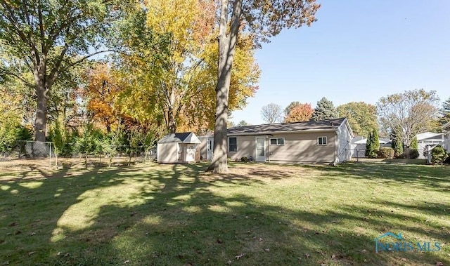 view of yard with a fenced backyard, a shed, and an outdoor structure