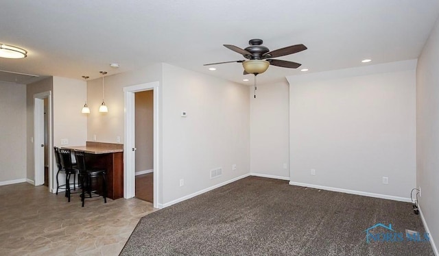 unfurnished living room featuring a ceiling fan, visible vents, baseboards, attic access, and recessed lighting