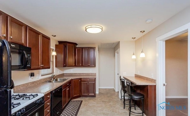 kitchen with black appliances, decorative light fixtures, baseboards, and a sink