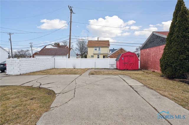 view of patio / terrace with fence private yard, a storage shed, and an outdoor structure