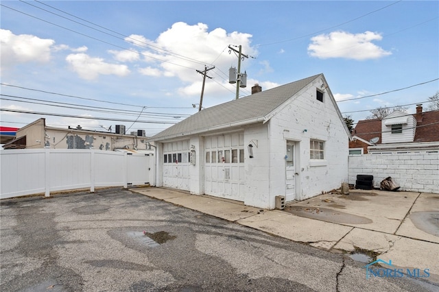 detached garage featuring fence