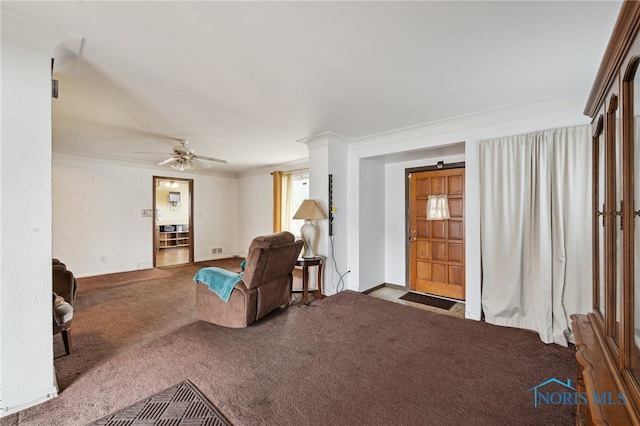 carpeted living area featuring a ceiling fan, baseboards, and ornamental molding