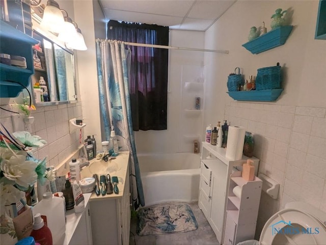 full bath featuring shower / bath combination with curtain, vanity, tile walls, and a paneled ceiling