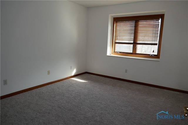 carpeted spare room featuring baseboards