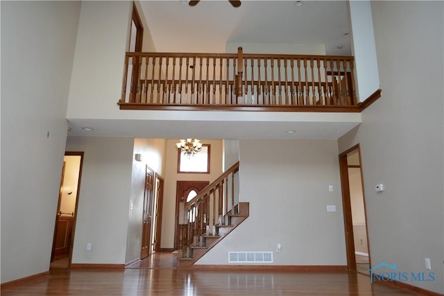 entryway with visible vents, a high ceiling, baseboards, and wood finished floors