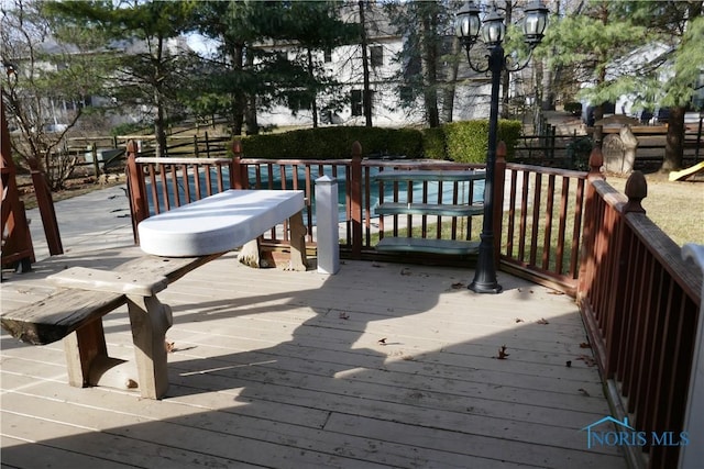 wooden deck featuring a fenced in pool and fence