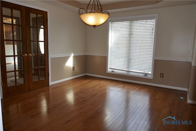 empty room with french doors, baseboards, and hardwood / wood-style floors