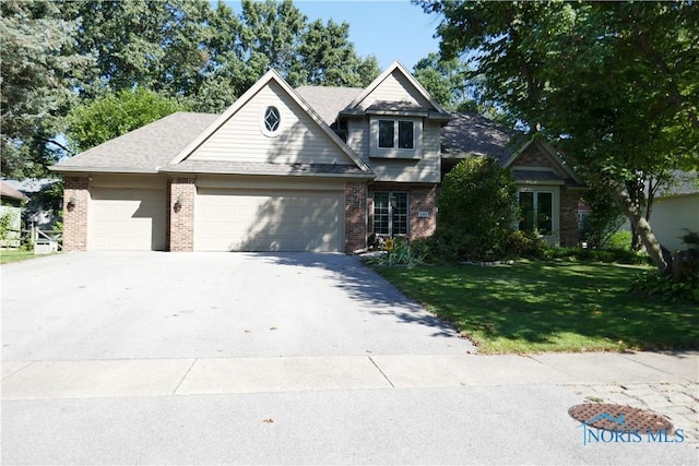 view of front of house with a garage, driveway, brick siding, and a front lawn