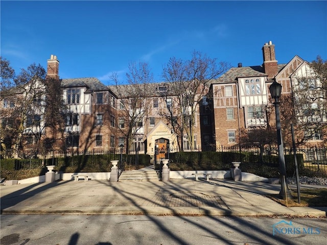 view of building exterior featuring a residential view and fence