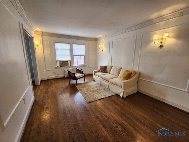 living room featuring a decorative wall, cooling unit, and dark wood-style floors