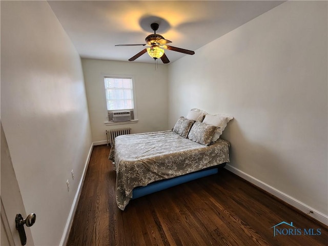 bedroom with cooling unit, radiator heating unit, baseboards, and wood finished floors