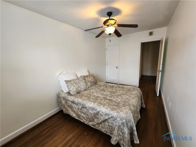 bedroom featuring a ceiling fan, baseboards, and wood finished floors