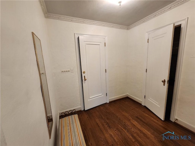 hallway featuring dark wood-style flooring, baseboards, and ornamental molding