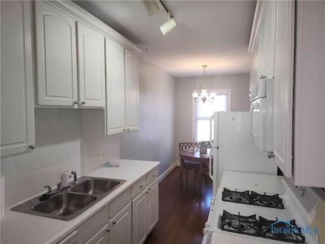 kitchen with white appliances, dark wood finished floors, white cabinetry, a notable chandelier, and backsplash