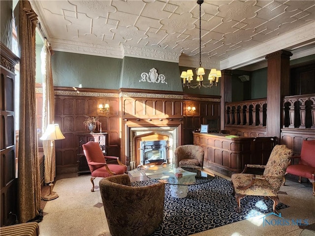 carpeted living room featuring a fireplace, crown molding, a textured wall, and a chandelier