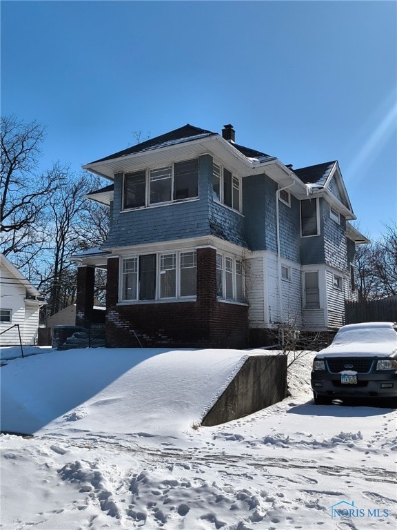 view of front of home with a chimney and fence