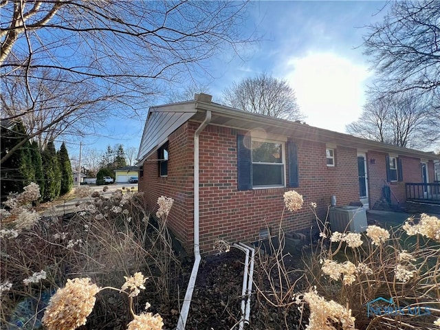 view of home's exterior with brick siding and cooling unit