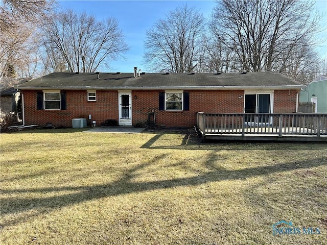 back of property featuring a yard, crawl space, a deck, central air condition unit, and brick siding