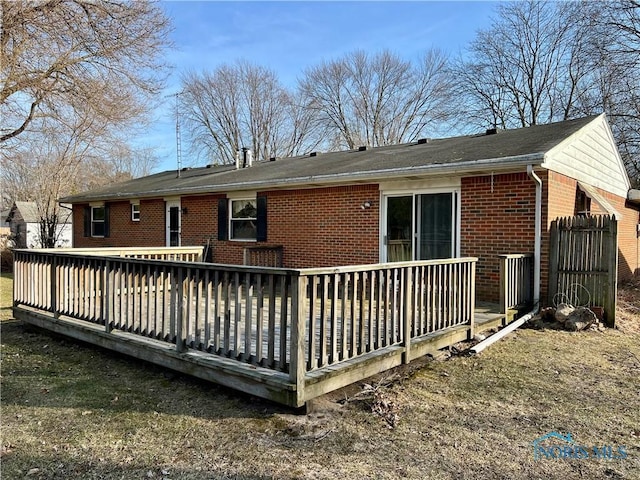 back of house featuring a wooden deck and brick siding