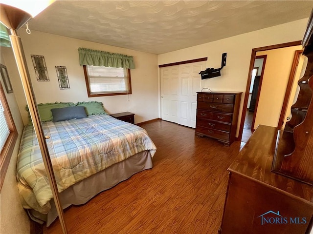 bedroom with dark wood-style flooring and a textured ceiling