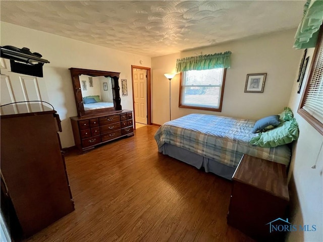 bedroom featuring wood finished floors and a textured ceiling